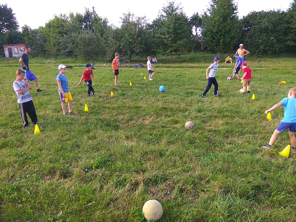 Hinchas viendo un partido de fútbol en un bar con pantallas gigantes