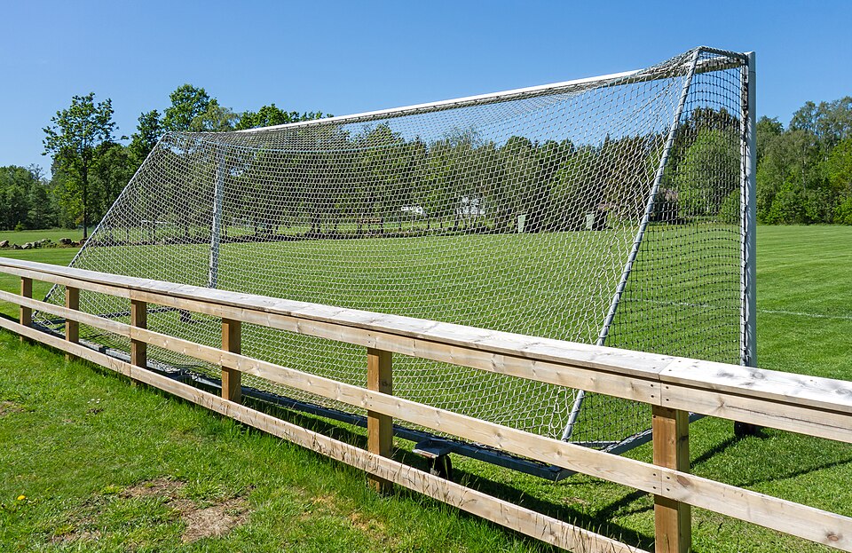 Pantalla de apuestas con cuotas y un balón de fútbol al lado